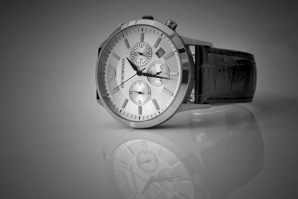 Best Watch Elegant black and white close-up of a luxury wristwatch with a reflective stainless steel body and leather strap. Best Watch